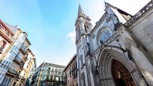Ángulo elevado de la Catedral de Santiago mostrando su torre y entrada principal con edificios históricos al fondo