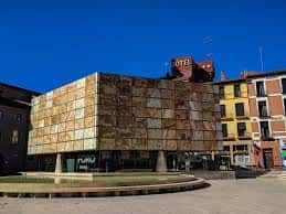 Edificio moderno de la Plaza de la Seo con fachada metálica y fuente en primer plano
