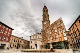 Plaza de la Seo Zaragoza con la torre del Micalet y el edificio de la Lonja bajo cielo nublado