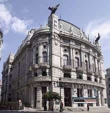 Ángulo lateral del Teatro García Barbón, resaltando su esquina curva y elementos escultóricos en la parte superior