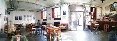 Vista panorámica del interior de Sala El Cachorro con barra, ventanas y mobiliario rústico