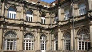 Detalle arquitectónico de la fachada del edificio con ventanas arqueadas y balcones