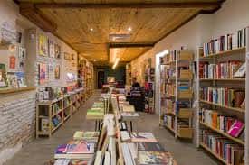 Interior de la librería La Montonera con estanterías llenas de libros y techo de madera