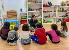 Actividad educativa en el interior del centro cívico con niños y una educadora