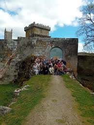 Foto grupal en el patio interior del castillo de la Ulloa, con el arco de entrada y la torre al fondo