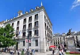 Vista exterior del edificio de la Delegación del Gobierno en Santander, con bandera española y plaza pública al frente