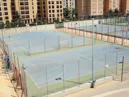 Pistas deportivas al aire libre del Colegio Portaceli con canchas de baloncesto y vallas perimetrales