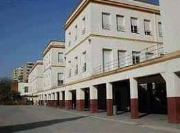 Fachada principal del edificio del Colegio Portaceli con arcos y columnas en tonos blancos y rojos