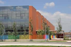 Edificio contemporáneo del hospital con fachada de vidrio y valla decorativa colorida