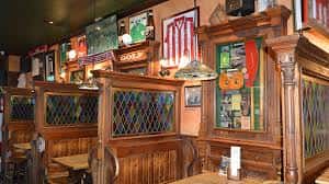 Interior del pub con decoración irlandesa y mesas de madera