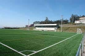 Campo de fútbol con graderío y portería en primer plano