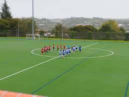 Partido de fútbol en el campo municipal con equipos en formación