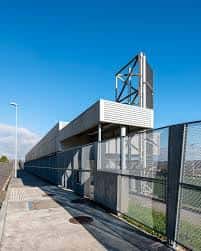 Estructura moderna de acceso al campo con valla metálica