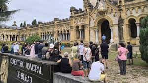 Grupo de personas reunidas frente a la entrada principal del Cementerio Municipal de Bilbao
