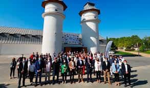 Grupo de personas reunidas frente a las torres blancas del espacio La Granja