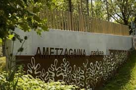 Señal de entrada del Parque Ametzagaina con diseño decorativo y vegetación