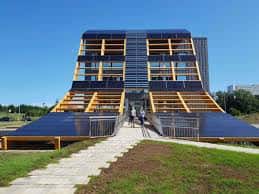 Estructura arquitectónica distintiva con escalinata y paneles solares en el complejo