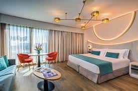 Habitación moderna con cama doble, decoración en tonos turquesa y luz ambiental curva
