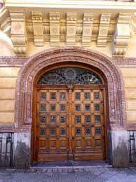 Detalle de la puerta principal con arco de medio punto y decoración arquitectónica en la calle Arbieto