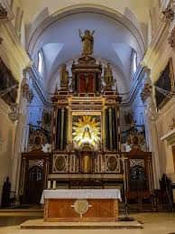 Interior de la iglesia con altar principal ornamentado y retablo dorado bajo bóveda