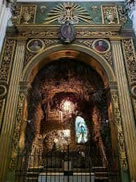 Detalle del retablo mayor con escultura de la Virgen y decoración barroca en oro