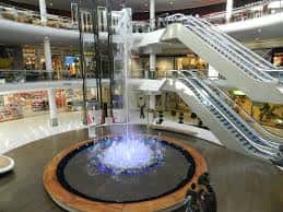 Interior del Centro Comercial Vallsur con una fuente central y escaleras mecánicas