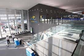 Interior de la terminal de cruceros con zona de embarque y escaleras mecánicas