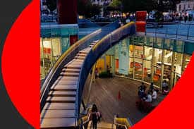 Vista exterior del Centro Municipal de Santutxu con escalera curva y fachada moderna iluminada