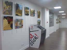 Pasillo interior del Centro Municipal con exposición de arte y máquina de información