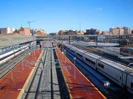 Vista panorámica de las vías y andenes de la estación con trenes en plataforma bajo cielo despejado