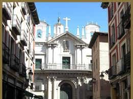Vista exterior de la iglesia desde una calle estrecha con cielo azul
