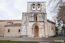 Plaza frontal del santuario con la entrada arqueada y la torre de campanas bajo un cielo nublado