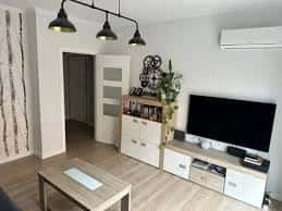 Sala de estar con sofá, televisor y decoración minimalista