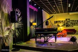 Escenario interior con piano de cola y ambiente de concierto