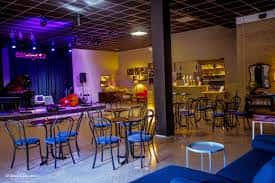 Sala interior con mesas, barra y escenario iluminado