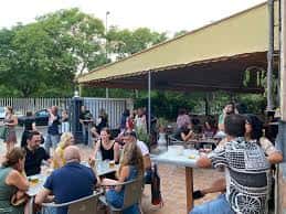 Terraza exterior con personas reunidas bajo toldo