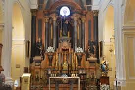 Interior de la iglesia mostrando el altar principal con retablo barroco y decoración dorada