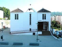 Fachada principal de la iglesia con cruz en la parte superior y rampa de acceso