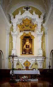 Altar mayor de la parroquia, con retablo dorado, estatua de la Virgen del Carmen y decoración religiosa tradicional