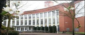 Edificio de la Facultad de Letras con flores de cerezo en primer plano