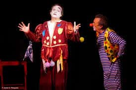 Actores disfrazados de payasos actuando en el escenario del teatro