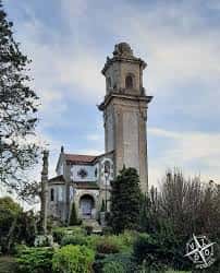 Iglesia del Sagrado Corazón de Jesús rodeada de vegetación, mostrando su torre y entorno natural