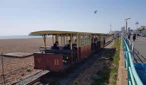 Tren eléctrico de Volk's Railway en movimiento junto al mar