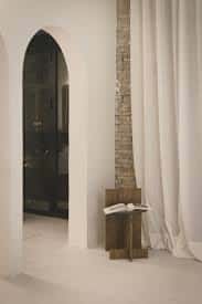 Detalle arquitectónico del espacio con arco y cortinas blancas