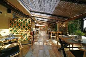 Interior del restaurante con mesas, sillas y decoración de bambú en el techo