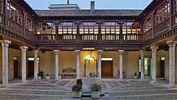 Patio interior del palacio con columnas clásicas y balcones de madera