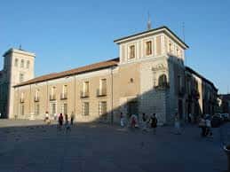 Vista diurna del palacio desde la plaza con personas caminando