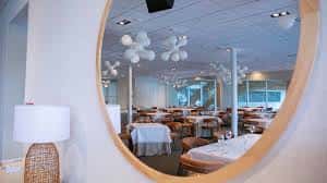 Interior del salón de eventos con mesas redondas y decoración moderna