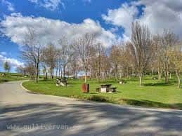 Sendero y zona arbolada en el Monte Arraiz con mesas de picnic