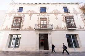 Fachada principal del Palacio de Valdeflores con detalles ornamentales y balcones